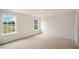 An empty bedroom featuring plush carpeting and scenic views through the windows at 120 Pisgah St, Sanford, NC 27330