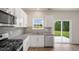 Close-up of kitchen featuring stainless steel appliances, gray backsplash and sliding back door at 120 Pisgah St, Sanford, NC 27330