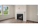 Living room featuring a fireplace with a white mantle, wood-look floors, and natural light at 120 Pisgah St, Sanford, NC 27330