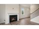 Open-concept living area with fireplace, wood-look floors, and staircase to the upper level at 120 Pisgah St, Sanford, NC 27330