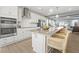 A modern kitchen featuring an expansive island with seating, sleek white cabinetry, and stainless steel appliances at 1257 S Blount Street # 201, Raleigh, NC 27601