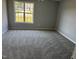 Cozy bedroom with neutral carpeting, fresh gray paint, and a bright window view at 128 Glengariff Ln, Clayton, NC 27520