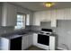 Updated kitchen featuring white cabinets, granite countertops, and black appliances at 128 Glengariff Ln, Clayton, NC 27520