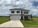 Two-story home featuring a two-car garage, neutral siding, and a well-manicured lawn at 131 E Victory View. Ter, Smithfield, NC 27577