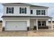 New two-story home with white siding, stone accents, dark shutters, and a two-car garage in a modern community at 131 E Victory View. Ter, Smithfield, NC 27577