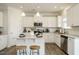 Modern white kitchen with granite countertops, stainless steel appliances, and a center island with seating at 131 E Victory View. Ter, Smithfield, NC 27577