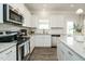 Bright kitchen featuring stainless steel appliances, white cabinets, granite countertops, and hardwood floors at 131 E Victory View. Ter, Smithfield, NC 27577
