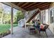 Covered patio with seating below a deck and stairs leading to a fenced backyard at 13121 Sargas St, Raleigh, NC 27614