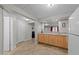 Basement wet bar area featuring natural wood cabinets, sink, refrigerator, and connection to theater seating at 13121 Sargas St, Raleigh, NC 27614