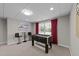 The finished basement features a foosball table, windows with red curtains, and comfortable seating area at 13121 Sargas St, Raleigh, NC 27614