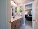 Bathroom with beige vanity, large mirror, and doorway to a bedroom at 13121 Sargas St, Raleigh, NC 27614