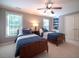 Comfortable bedroom with two twin beds, built-in shelving, and ample natural light at 13121 Sargas St, Raleigh, NC 27614