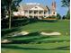 Estate home featuring a golf course view with a covered balcony, and lush green landscaping at 13121 Sargas St, Raleigh, NC 27614