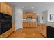Well-appointed kitchen with hardwood floors, wooden cabinets, and modern black appliances at 13121 Sargas St, Raleigh, NC 27614