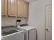 Laundry room featuring a side-by-side washer and dryer and upper cabinets at 13121 Sargas St, Raleigh, NC 27614