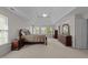 Bright main bedroom with windows, ceiling fan, and classic dark wood furniture at 13121 Sargas St, Raleigh, NC 27614
