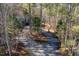 A gravel driveway passes through the forest toward a blue house at 1617 Jenkins Rd, Wake Forest, NC 27587