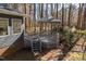 Charming gazebo with stairs and latticework skirt sits amid lush trees next to the house at 1617 Jenkins Rd, Wake Forest, NC 27587