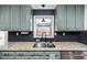 Updated kitchen with granite countertops, stainless steel sink and black herringbone backsplash at 1617 Jenkins Rd, Wake Forest, NC 27587