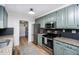 Bright eat-in kitchen with light green cabinets, stainless steel appliances and black backsplash at 1617 Jenkins Rd, Wake Forest, NC 27587