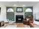 Living room featuring a fireplace with white mantle, decorative mirror and arch-top windows at 1617 Jenkins Rd, Wake Forest, NC 27587