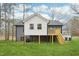 Expansive backyard showcasing a raised addition and wooden deck with stairs, ideal for enjoying the outdoors at 1911 Stadium Dr, Durham, NC 27705