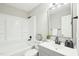 Bathroom featuring a tub, gray vanity with countertop, black faucet, and framed mirror at 1911 Stadium Dr, Durham, NC 27705