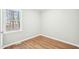 Bedroom features wood flooring, a bright window overlooking a wooded area, and neutral paint at 1911 Stadium Dr, Durham, NC 27705