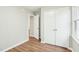 Bedroom featuring wood flooring, neutral paint, white trim, a double-door closet, and a doorway at 1911 Stadium Dr, Durham, NC 27705