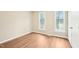 Bedroom features wood flooring, neutral paint, bright windows, and a white door at 1911 Stadium Dr, Durham, NC 27705