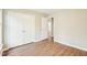 Bedroom featuring wood flooring, neutral paint, white trim, double-door closet, and doorway at 1911 Stadium Dr, Durham, NC 27705