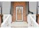Close up of front door framed by brick and white railings at 1911 Stadium Dr, Durham, NC 27705