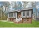 Inviting two-story home showcasing a brick and siding exterior, complemented by lush green lawn and scenic landscaping at 1911 Stadium Dr, Durham, NC 27705
