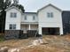 A view of a two-story home with gray stone accents and a two-car garage undergoing construction at 1912 Harrell Cove Ct # 171 Gunnison Cr, Fuquay Varina, NC 27526