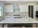 Bright kitchen featuring white cabinets, a subway tile backsplash, and a large center island with marble countertop at 1912 Harrell Cove Ct # 171 Gunnison Cr, Fuquay Varina, NC 27526