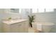 Bright bathroom with a soaking tub, marble countertop, and stylish fixtures at 206 Pine St, Fuquay Varina, NC 27526
