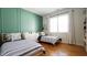 Cozy bedroom featuring hardwood floors, twin beds, and accent wall with decorative shelves at 206 Pine St, Fuquay Varina, NC 27526