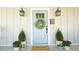 Charming entrance with a light blue door, decorative wreath, and potted plants, creating a welcoming atmosphere at 206 Pine St, Fuquay Varina, NC 27526