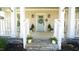 Inviting front porch with blue door and decorative plants, leading up with stone steps at 206 Pine St, Fuquay Varina, NC 27526