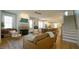 Bright living room featuring a fireplace, hardwood floors, and an open layout connecting to the dining area and stairs at 206 Pine St, Fuquay Varina, NC 27526