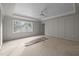 Spacious bedroom featuring a tray ceiling with a fan and a large window offering views of the surrounding area at 207 Holleman St, Apex, NC 27502