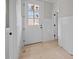Bright entryway with white wainscoting, light wood floors, and a door with glass panes and matte black hardware at 207 Holleman St, Apex, NC 27502