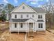Beautiful two-story home with a covered porch and black accents against the white siding at 207 Holleman St, Apex, NC 27502