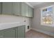 Well-organized laundry room with stylish cabinetry, hardware, and countertops at 207 Holleman St, Apex, NC 27502