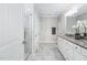 Bathroom with double sinks, white cabinets, marble flooring, and a walk-in shower at 216 Kalmia Dr, Durham, NC 27703