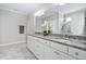 Bathroom with white cabinets, granite counters, double sinks, and marble flooring at 216 Kalmia Dr, Durham, NC 27703