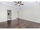 Spacious primary bedroom featuring hardwood floors, ceiling fan, and ensuite bathroom with double doors at 216 Kalmia Dr, Durham, NC 27703
