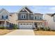 Charming two-story home featuring a two-car garage and inviting curb appeal with modern gray siding at 2404 Glade Mill Ct, Fuquay Varina, NC 27526
