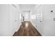 Well-lit hallway with hardwood floors and white doors, offering a clean and modern aesthetic at 2404 Glade Mill Ct, Fuquay Varina, NC 27526