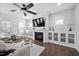 Cozy living room with built-in cabinets, fireplace, and a ceiling fan, perfect for relaxation at 2404 Glade Mill Ct, Fuquay Varina, NC 27526